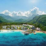 Aerial view of Sandals Saint Vincent between a turquoise bay and lush green mountains