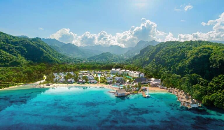 Aerial view of Sandals Saint Vincent between a turquoise bay and lush green mountains