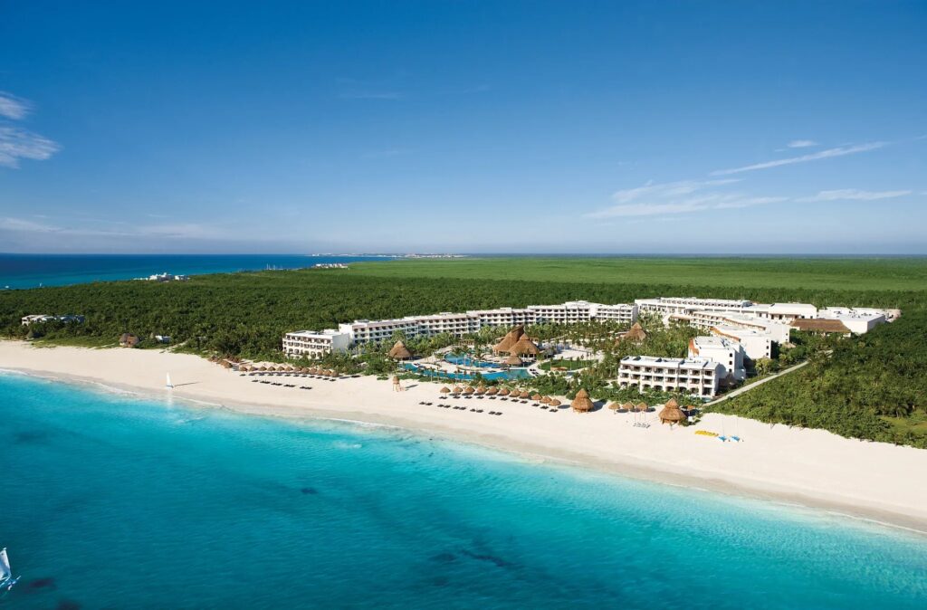 Aerial view of Secrets Maroma Beach Riviera Cancun beside a wide white-sand beach and turquoise water