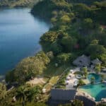 Aerial view of Secrets Papagayo Costa Rica with the main pool, tropical hillside and calm Papagayo Gulf shoreline