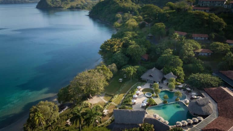 Aerial view of Secrets Papagayo Costa Rica with the main pool, tropical hillside and calm Papagayo Gulf shoreline