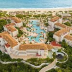 Aerial view of Secrets Playa Mujeres with resort buildings, pools and the beach in Mexico