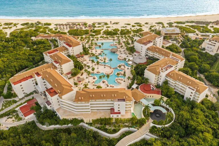 Aerial view of Secrets Playa Mujeres with resort buildings, pools and the beach in Mexico