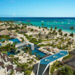 Aerial view of Secrets Royal Beach Punta Cana with pools, palm trees and the Caribbean beachfront