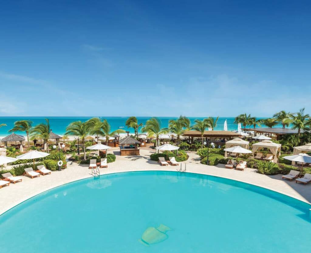 Turquoise pool, cabanas, palms and Grace Bay beach at Seven Stars Resort & Spa in Turks and Caicos