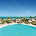 Turquoise pool, cabanas, palms and Grace Bay beach at Seven Stars Resort & Spa in Turks and Caicos
