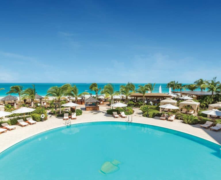 Turquoise pool, cabanas, palms and Grace Bay beach at Seven Stars Resort & Spa in Turks and Caicos