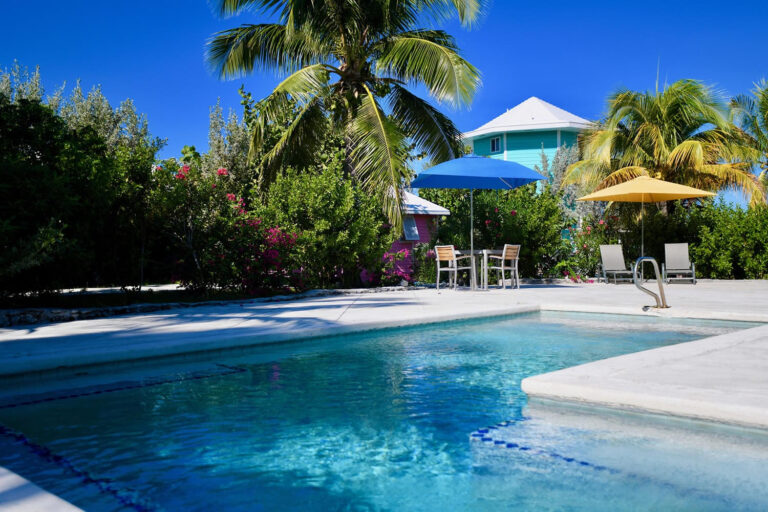 Blue swimming pool, palms and colorful resort buildings at Staniel Cay Yacht Club in the Exumas, Bahamas