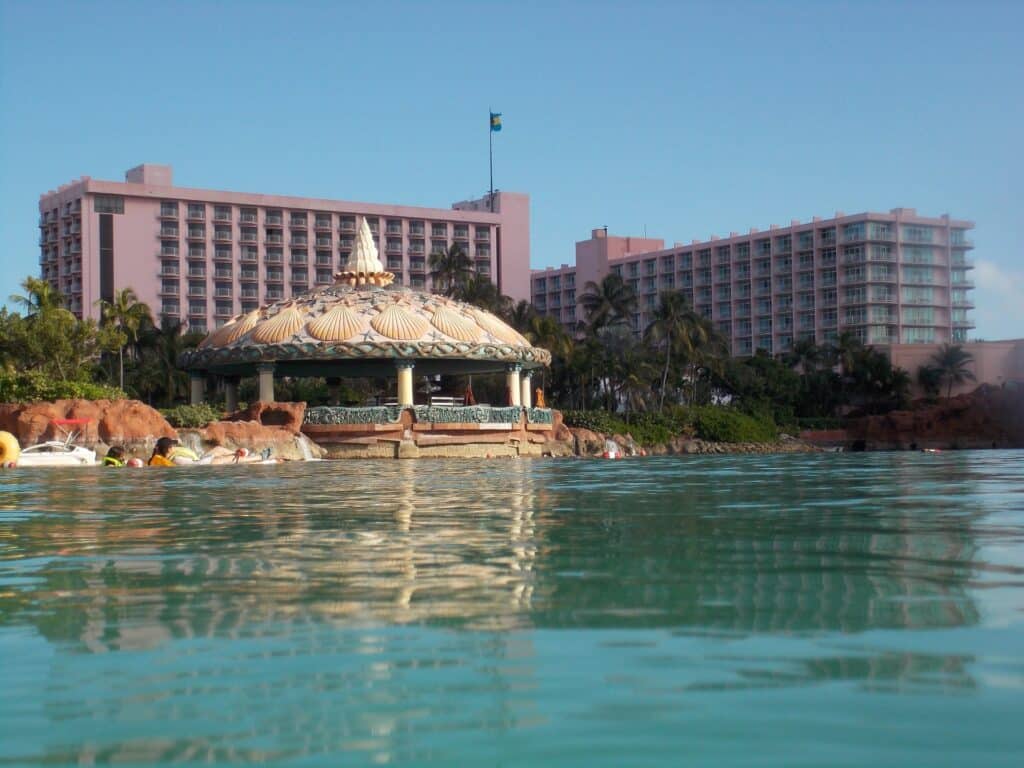 Coral Towers at Atlantis Paradise Island rising behind a turquoise lagoon and shell-topped pavilion