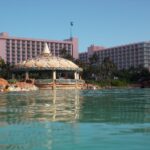 Coral Towers at Atlantis Paradise Island rising behind a turquoise lagoon and shell-topped pavilion