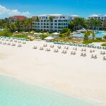 Aerial view of The Palms Turks and Caicos along Grace Bay Beach with resort buildings and pool