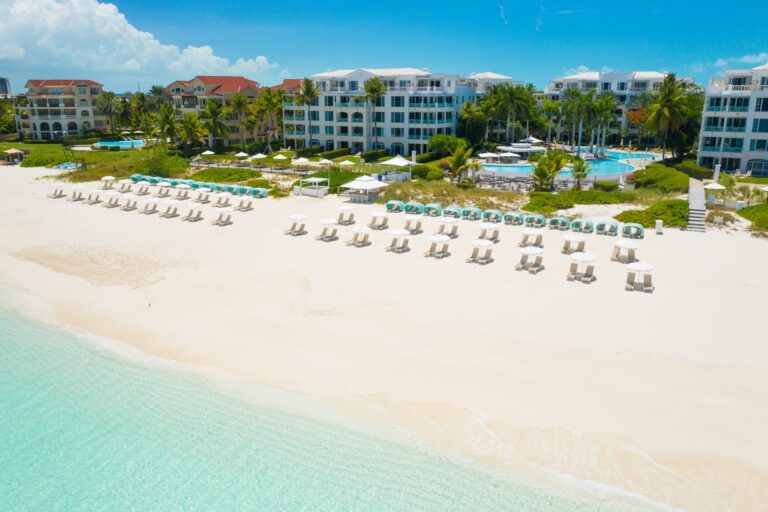 Aerial view of The Palms Turks and Caicos along Grace Bay Beach with resort buildings and pool