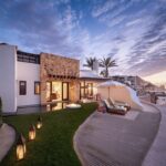 Waldorf Astoria Los Cabos Pedregal resort terrace and buildings overlooking the Pacific coast at dusk